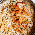 Skillet of creamy chicken Alfredo tossed with fettuccine and parsley.